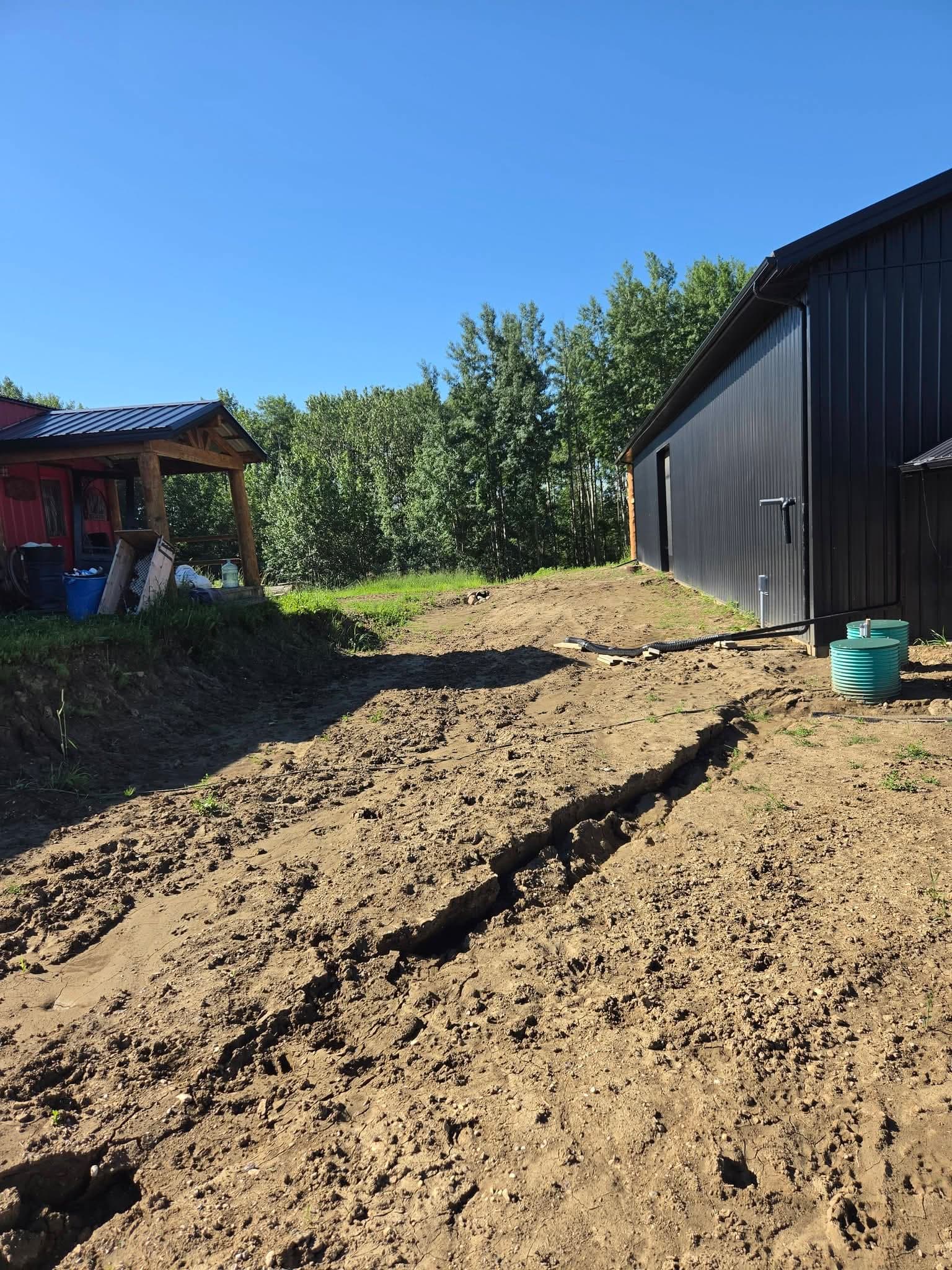 Drainage trench and pipe run alongside a shop building