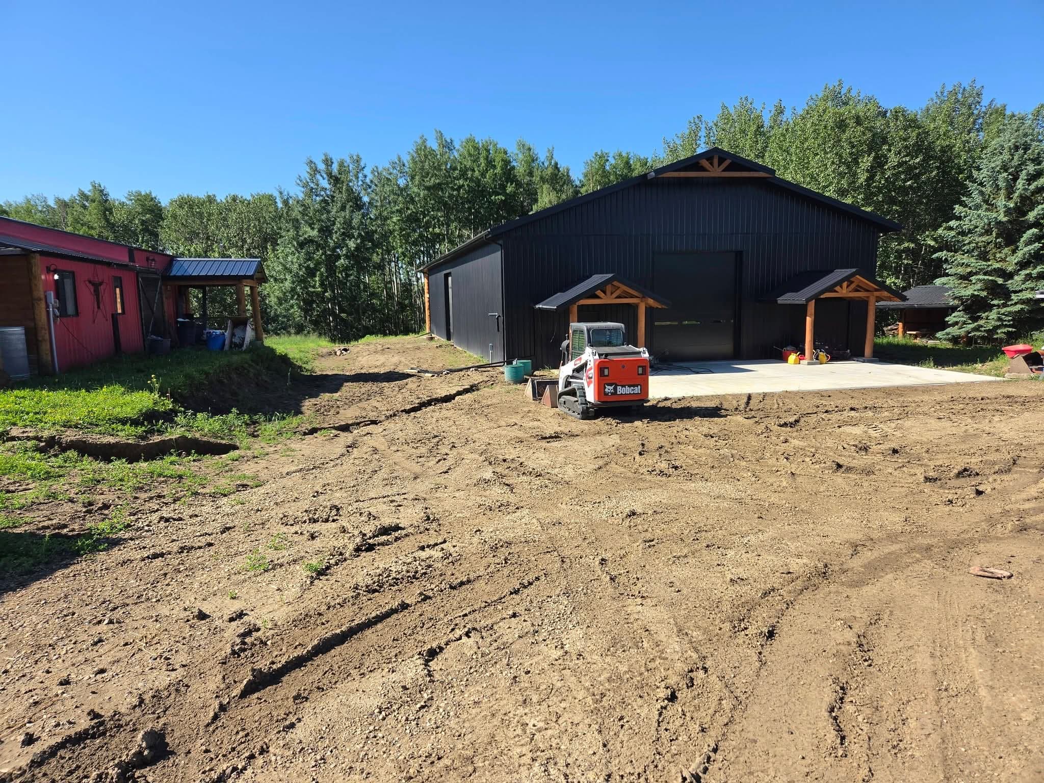 Bobcat T450 track loader on rough dirt beside a new shop